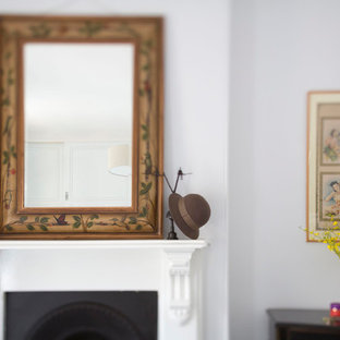Idee per una grande camera matrimoniale etnica con pareti bianche, camino classico e cornice del camino in legno