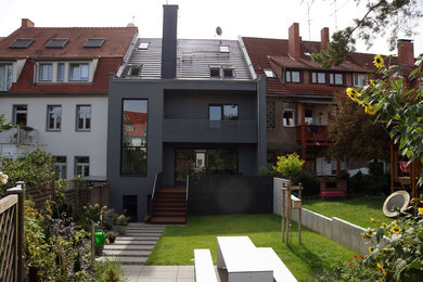 Mittelgroßes, Dreistöckiges Modernes Reihenhaus mit Putzfassade, grauer Fassadenfarbe und Ziegeldach in Sonstige