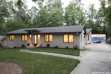 Contemporary beige one-story house exterior idea in Raleigh with a shed roof and a shingle roof