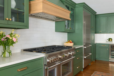 Example of a large transitional l-shaped light wood floor and brown floor eat-in kitchen design in Philadelphia with a drop-in sink, beaded inset cabinets, green cabinets, quartz countertops, white backsplash, marble backsplash, stainless steel appliances, an island and white countertops