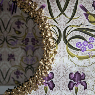 Ornate Brass Mirror Against Botanical Wallpaper