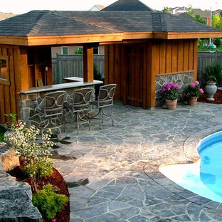 Idéer för en stor klassisk pool på baksidan av huset, med poolhus och naturstensplattor