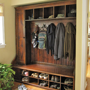 ニューヨークの中サイズのトラディショナルスタイルのおしゃれなマッドルーム (黄色い壁、無垢フローリング) の写真