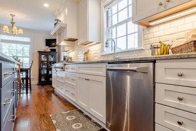 Eat-in kitchen - huge traditional galley medium tone wood floor eat-in kitchen idea in Miami with an undermount sink, shaker cabinets, white cabinets, granite countertops, white backsplash, subway tile backsplash, stainless steel appliances and an island