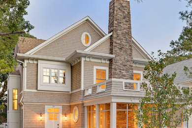 Inspiration for a beach style three-storey beige exterior in Other with wood siding.