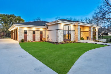 Large contemporary beige one-story stone exterior home idea in Minneapolis with a hip roof