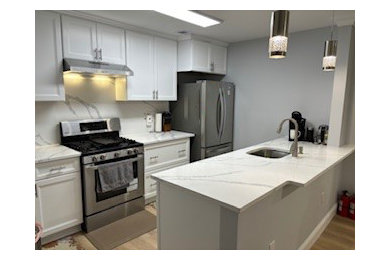 Example of a small classic galley enclosed kitchen design in New York with shaker cabinets, white cabinets, quartz countertops and white countertops
