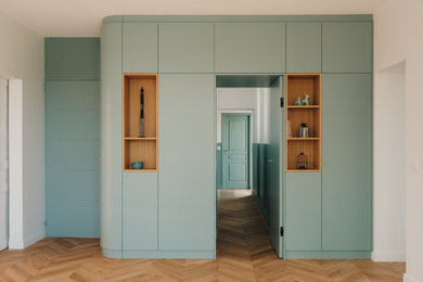 Inspiration pour un vestibule design de taille moyenne avec un mur bleu, parquet clair, une porte simple et une porte bleue.