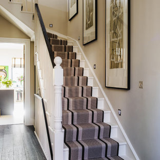 На фото: угловая лестница в классическом стиле с крашенными деревянными ступенями и крашенными деревянными подступенками с