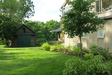 This is an example of a mid-sized transitional partial sun front yard stone landscaping in Boston for summer.