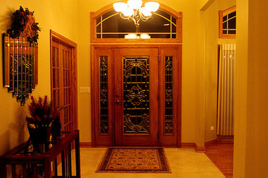 Entryway - large traditional terra-cotta tile entryway idea in Chicago with beige walls and a glass front door