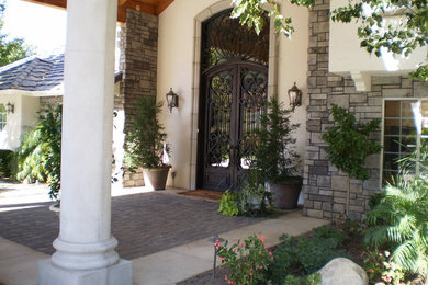 Entryway - mid-sized traditional concrete floor and beige floor entryway idea in Los Angeles with beige walls and a glass front door