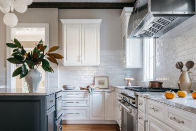 Design ideas for a mid-sized eat-in kitchen in Chicago with recessed-panel cabinets, white cabinets, quartzite benchtops, white splashback, subway tile splashback, stainless steel appliances, with island, white benchtop, medium hardwood floors, brown floor and exposed beam.
