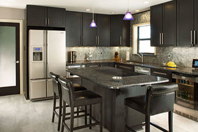 Photo of a mid-sized contemporary l-shaped kitchen in Dallas with an undermount sink, shaker cabinets, black cabinets, granite benchtops, grey splashback, stainless steel appliances, porcelain floors, with island and grey floor.
