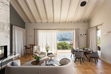 Immagine di un grande soggiorno scandinavo stile loft con libreria, pareti beige, parquet chiaro, camino lineare Ribbon, cornice del camino in pietra, pavimento beige e travi a vista