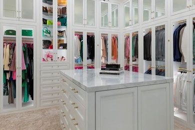 Ejemplo de armario vestidor unisex tradicional renovado grande con armarios con rebordes decorativos, puertas de armario blancas, moqueta y suelo beige