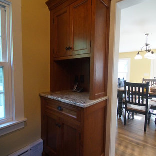 Inspiration for a large country l-shaped kitchen pantry in Bridgeport with a farmhouse sink, recessed-panel cabinets, medium wood cabinets, granite benchtops, beige splashback, subway tile splashback, stainless steel appliances, laminate floors, with island, brown floor and beige benchtop.