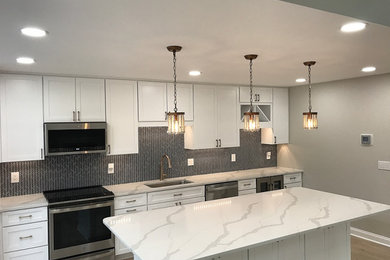 Design ideas for a large transitional eat-in kitchen in Baltimore with an undermount sink, shaker cabinets, white cabinets, quartz benchtops, blue splashback, mosaic tile splashback, stainless steel appliances, vinyl floors, with island, brown floor and white benchtop.
