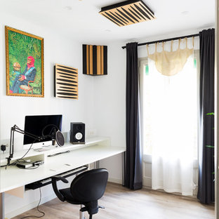 Diseño de despacho contemporáneo con paredes blancas, suelo de madera clara, escritorio independiente y suelo beige