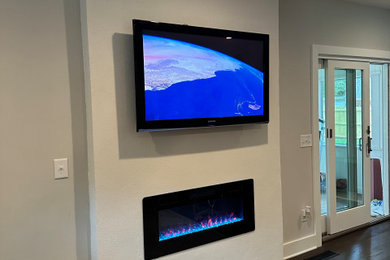Example of a small minimalist living room design in Charleston with white walls, a standard fireplace, a plaster fireplace and a wall-mounted tv