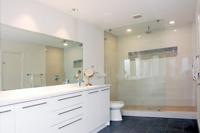 Inspiration for a mid-sized contemporary master bathroom in Dallas with an undermount sink, flat-panel cabinets, white cabinets, quartzite benchtops, a freestanding tub, an open shower, a two-piece toilet, white tile, porcelain tile, white walls and porcelain floors.