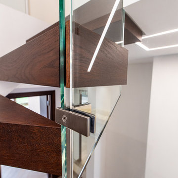 Floating stairs with frameless glass balustrade in chocolate brown colour