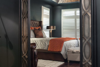 Country master bedroom in St Louis with black walls and medium hardwood floors.