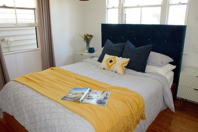This is an example of a small scandinavian bedroom in Brisbane with white walls and medium hardwood floors.
