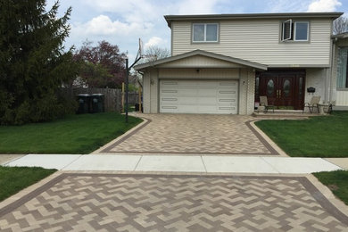 This is an example of a large traditional full sun front yard stone driveway in Chicago.