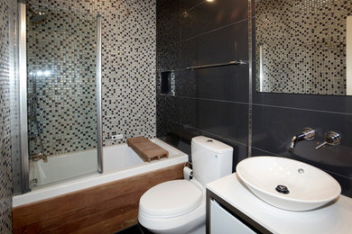 Inspiration for a small contemporary 3/4 bathroom remodel in DC Metro with flat-panel cabinets, white cabinets, a two-piece toilet, a vessel sink, solid surface countertops and gray walls