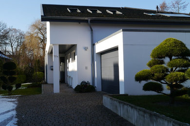 Großes, Zweistöckiges Modernes Einfamilienhaus mit Putzfassade, weißer Fassadenfarbe, Pultdach und Ziegeldach in Hannover
