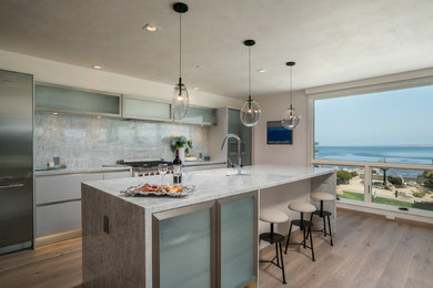 Inspiration for a large contemporary single-wall light wood floor and beige floor open concept kitchen remodel in Other with an undermount sink, flat-panel cabinets, white cabinets, gray backsplash, stainless steel appliances, an island, stone slab backsplash, quartzite countertops and white countertops