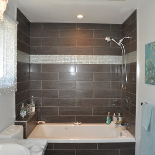 Foto di una piccola stanza da bagno padronale minimalista con ante lisce, ante in legno scuro, piastrelle marroni, lavabo a bacinella, vasca da incasso, vasca/doccia, WC monopezzo, piastrelle in ceramica, pareti grigie e pavimento con piastrelle in ceramica