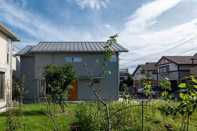 Foto de fachada de casa gris y gris escandinava de tamaño medio de dos plantas con revestimiento de estuco, tejado a dos aguas y tejado de metal