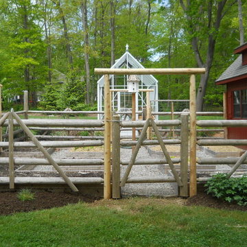 A home growing complex includes a barn, greenhouse and vegetable garden with rai