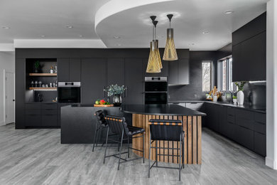 Inspiration for a large modern kitchen in Denver with flat-panel cabinets, black cabinets, granite benchtops, black splashback, granite splashback, with island and black benchtop.