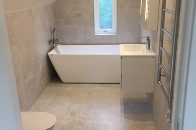 На фото: главная ванная комната среднего размера с плоскими фасадами, белыми фасадами, отдельно стоящей ванной, унитазом-моноблоком, серой плиткой, керамической плиткой, серыми стенами, полом из керамической плитки, столешницей из плитки и серым полом