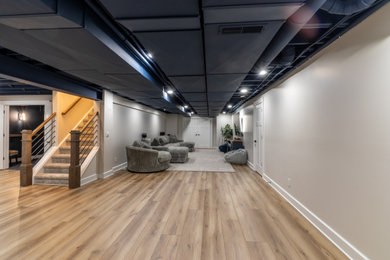 Inspiration for a huge modern underground laminate floor and brown floor basement remodel in Cleveland with a home theater and white walls