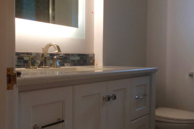 Inspiration for a small transitional multicolored tile ceramic tile, multicolored floor and single-sink alcove shower remodel in Kansas City with flat-panel cabinets, white cabinets, an undermount sink, quartzite countertops, a hinged shower door, white countertops and a freestanding vanity
