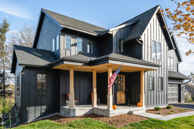 Example of a mid-sized black two-story vinyl and board and batten house exterior design in Minneapolis with a shingle roof and a black roof