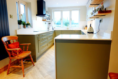 This is an example of a medium sized traditional u-shaped kitchen/diner in Other with a built-in sink, shaker cabinets, light wood cabinets, quartz worktops, white splashback, engineered quartz splashback, stainless steel appliances, vinyl flooring, a breakfast bar, beige floors, white worktops and feature lighting.