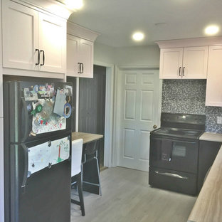 Inspiration för ett mellanstort shabby chic-inspirerat brun brunt kök, med en nedsänkt diskho, släta luckor, svarta skåp, laminatbänkskiva, grått stänkskydd, stänkskydd i mosaik, svarta vitvaror, vinylgolv och brunt golv