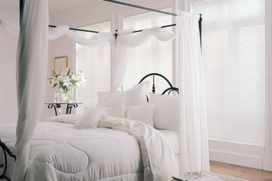 Example of a mid-sized transitional master medium tone wood floor and brown floor bedroom design in New York with white walls and no fireplace