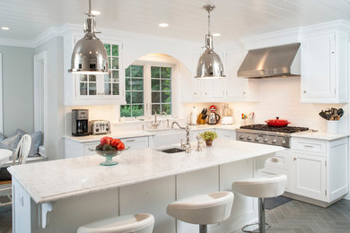 Inspiration for a mid-sized transitional l-shaped eat-in kitchen in New York with a farmhouse sink, shaker cabinets, white cabinets, marble benchtops, white splashback, subway tile splashback, stainless steel appliances, slate floors, with island and grey floor.