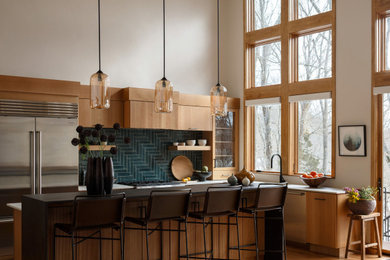Example of a large 1960s light wood floor kitchen design in Boston with flat-panel cabinets, light wood cabinets, ceramic backsplash, stainless steel appliances and an island