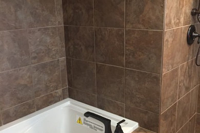 Mid-sized transitional master brown tile and porcelain tile porcelain tile and brown floor bathroom photo in Other with a two-piece toilet and brown walls