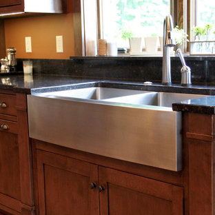 Ejemplo de cocina de estilo americano, grande, cerrada, con fregadero sobremueble, armarios con paneles empotrados, puertas de armario de madera oscura, encimera de cuarzo compacto, electrodomésticos de acero inoxidable, suelo de baldosas de porcelana, una isla, salpicadero de ladrillos y encimeras negras