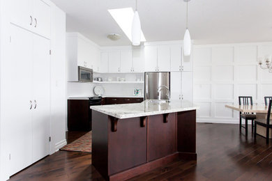 Open concept kitchen - small modern l-shaped medium tone wood floor open concept kitchen idea in Toronto with an undermount sink, flat-panel cabinets, white cabinets, granite countertops, white backsplash, porcelain backsplash, stainless steel appliances and an island