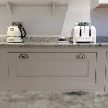 A light, bright, white hand painted kitchen with open shelving and large island