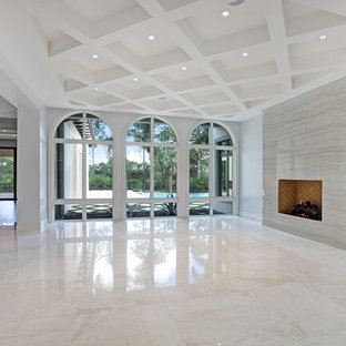 This is an example of an expansive mediterranean formal open plan living room in Miami with white walls, marble flooring, a standard fireplace and no tv.